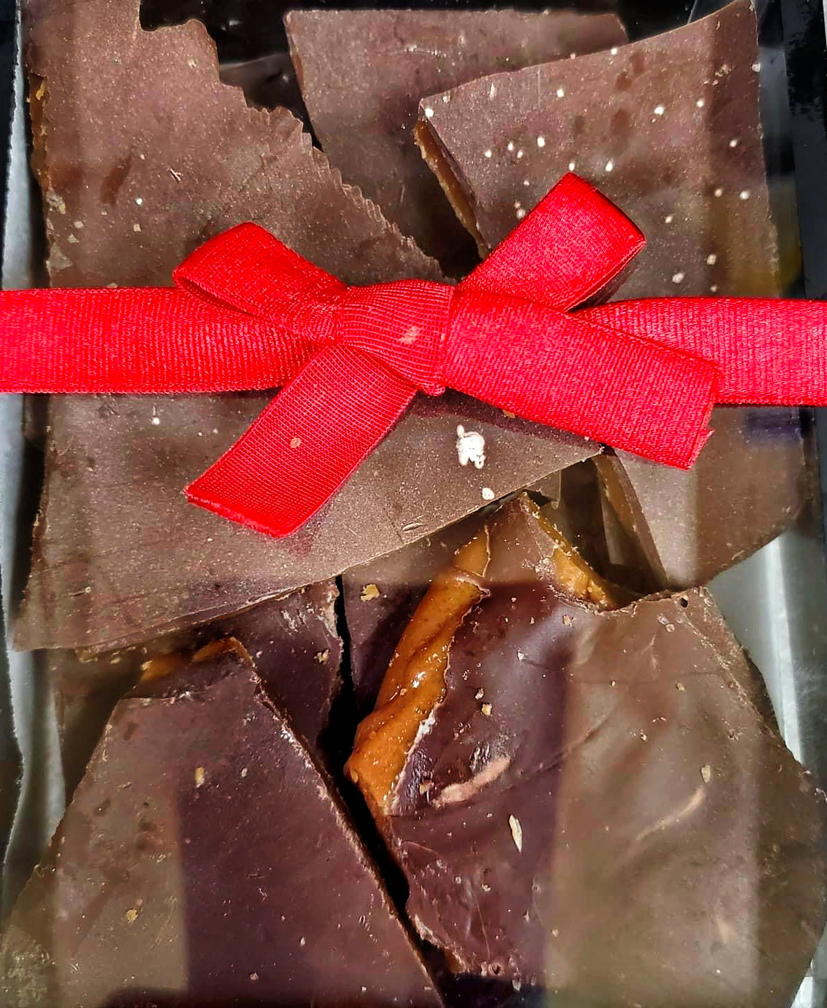 Chocolate toffee pieces with a red ribbon.