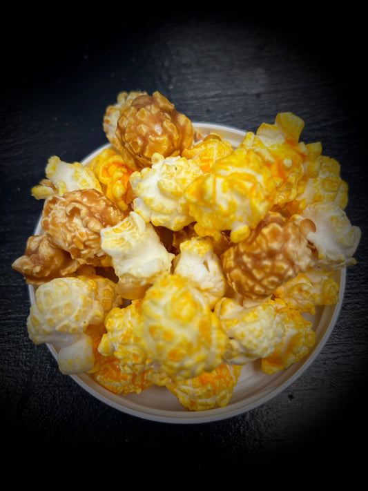 Joyful Mix popcorn with caramel, yellow cheddar, and white cheddar in a bowl.