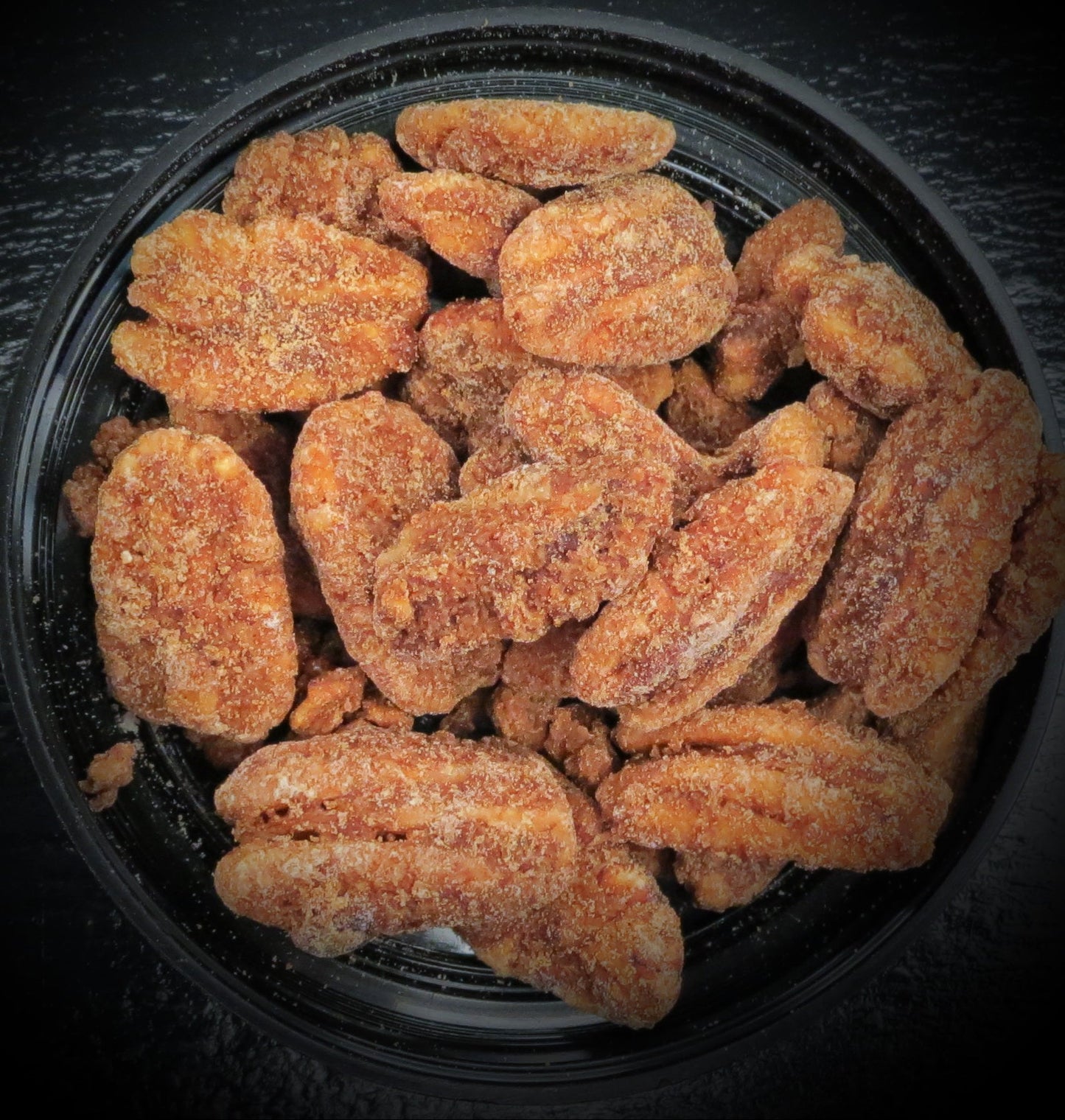 Cinnamon sugar pecans in black bowl.