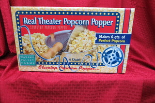 Whirley Pop popcorn popper packaging on red fabric background.