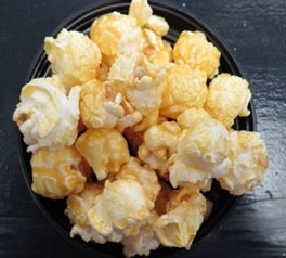 Butter Rum flavored popcorn in a black bowl.