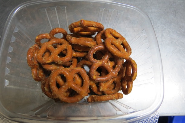 Freshly baked pretzels in a clear container.