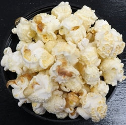 Sour cream and onion flavored popcorn in a black bowl.