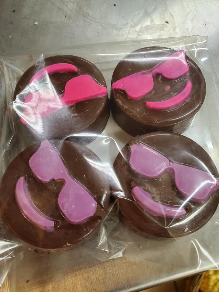 Chocolate Peanut Butter Oreo cookies decorated with pink chocolate designs in packaging.