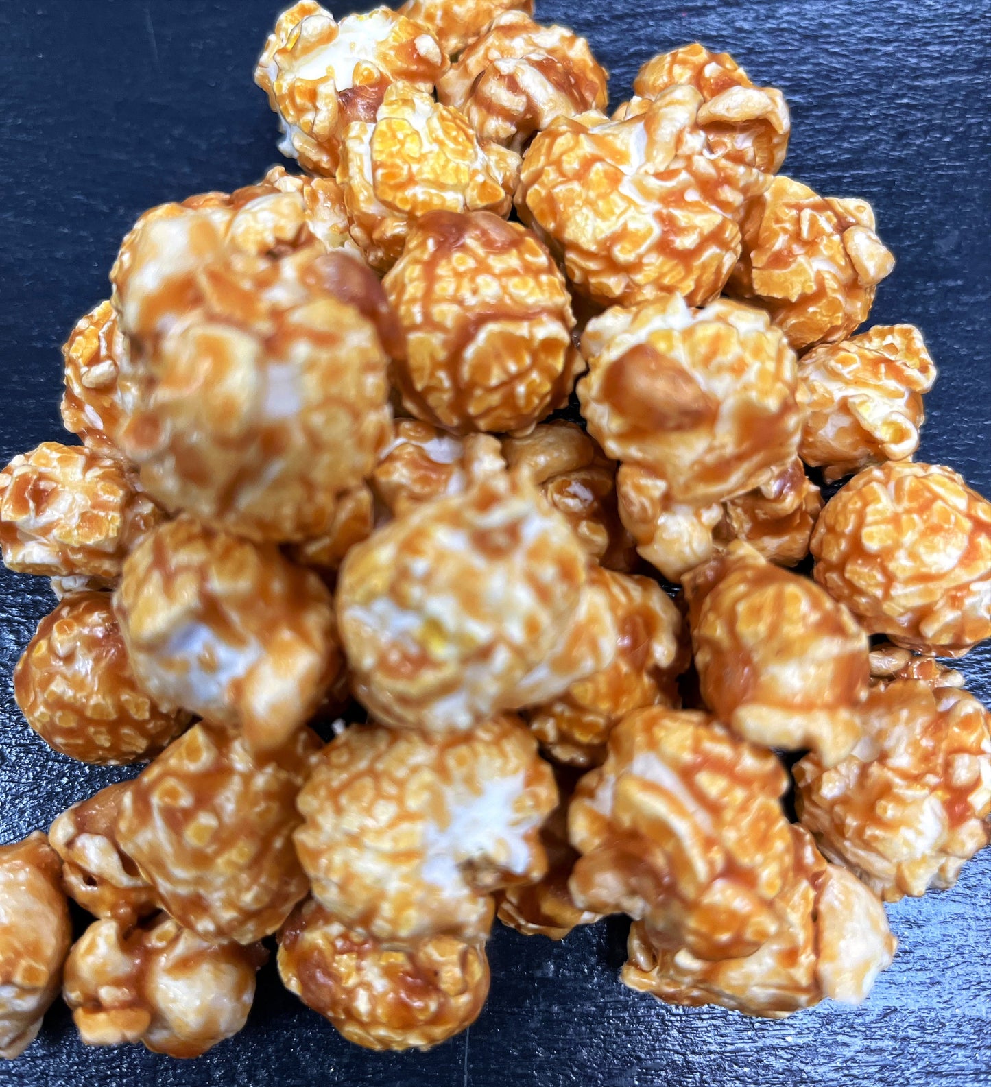 Sweet cream caramel popcorn with real butter on a dark background.