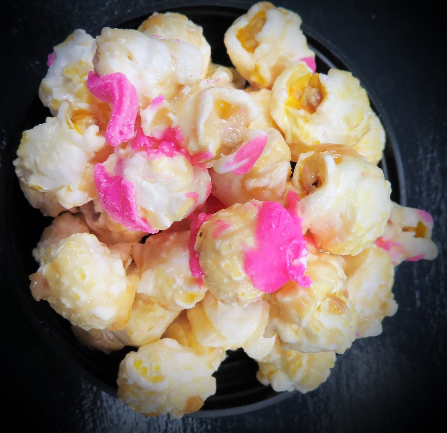 Champagne flavored popcorn drizzled with creamy strawberry chocolate