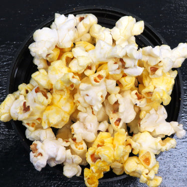 Movie theater style salt and butter popcorn in a black bowl.
