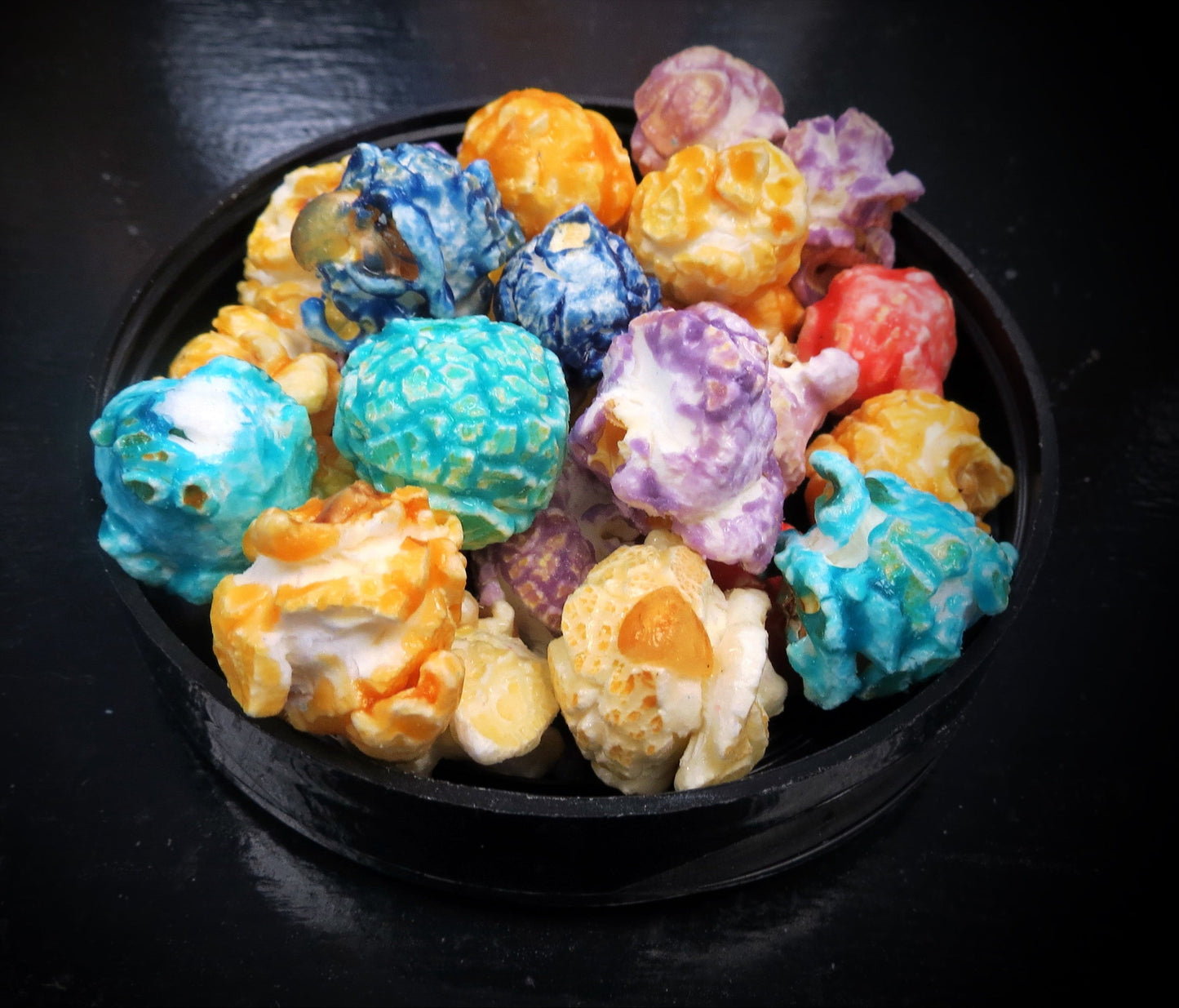 Colorful Craizy Mix popcorn in a black bowl, showcasing a rainbow of fruit flavors.